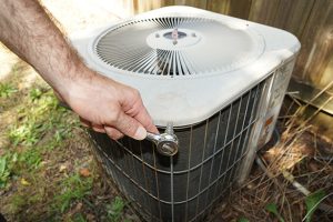 Removing screws from air conditioning condenser unit fan assembly housing