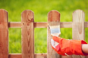 Protective sealant being applied to a wooden fence