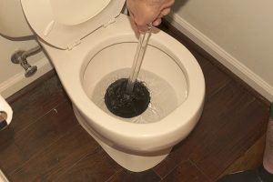 depressed plunger in a clogged toilet that was overflowing