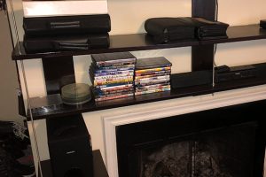 DIY wall mounted shelving unit built and anchored to surround a fireplace