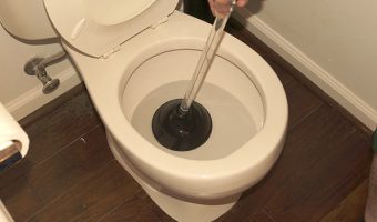 plunger in a clogged toilet that was overflowing